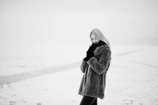 Portret van jonge elegantie blond meisje op de achtergrond van een bont jas — Stockfoto