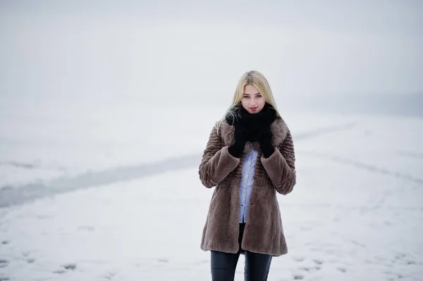 Porträt der jungen Eleganz blondes Mädchen in einem Pelzmantel Hintergrund — Stockfoto