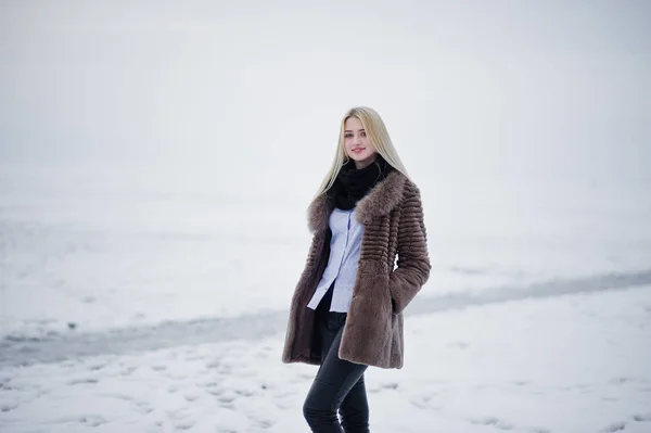 Portret van jonge elegantie blond meisje op de achtergrond van een bont jas — Stockfoto