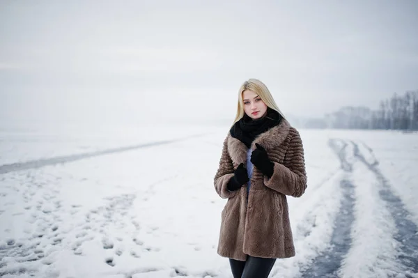 Portrait of young elegance blonde girl in a fur coat background — Stock Photo, Image