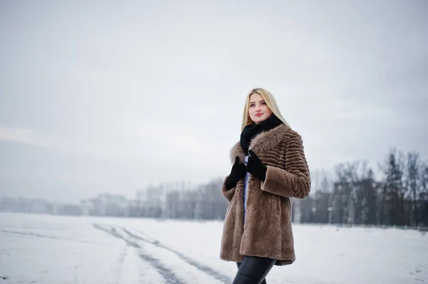 Portrait of young elegance blonde girl in a fur coat background — Stock Photo, Image