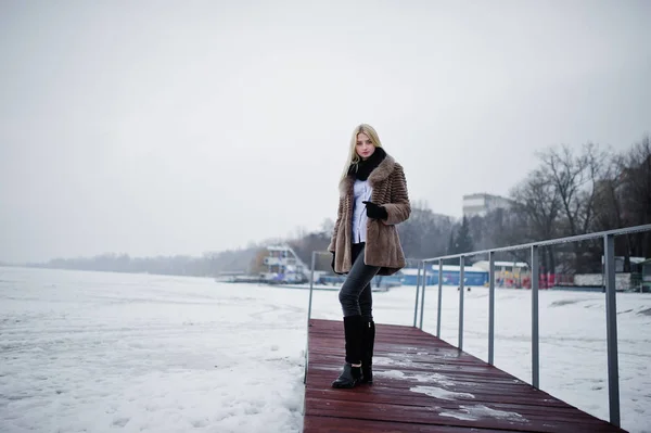 Portret van jonge elegantie blond meisje in een bontjas op pier bac — Stockfoto