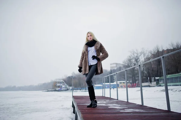 Portret van jonge elegantie blond meisje in een bontjas op pier bac — Stockfoto