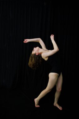 Atlama ve siyah bir arka plan üzerinde dans dansçı kız. Stüdyo sh