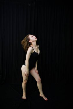 Atlama ve siyah bir arka plan üzerinde dans dansçı kız. Stüdyo sh