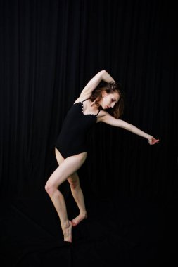 Atlama ve siyah bir arka plan üzerinde dans dansçı kız. Stüdyo sh