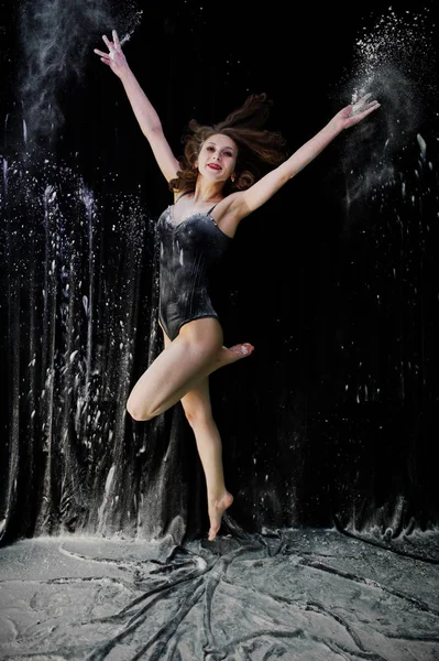 Танцовщица прыгает и танцует в белой пыли с мукой на — стоковое фото