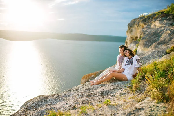 Casal vestindo no vestido com um padrão sentado em terra bonita — Fotografia de Stock