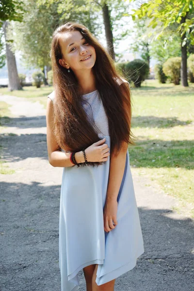 Portret van prachtige tienermeisje in blauwe blouse, tegen groen — Stockfoto