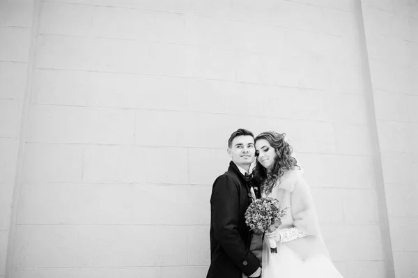 Casal jovem no dia frio de inverno contra a parede de pedra branca — Fotografia de Stock