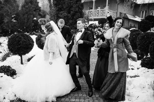 Pareja de bodas con damas de honor y los mejores hombres se divierten en invierno — Foto de Stock