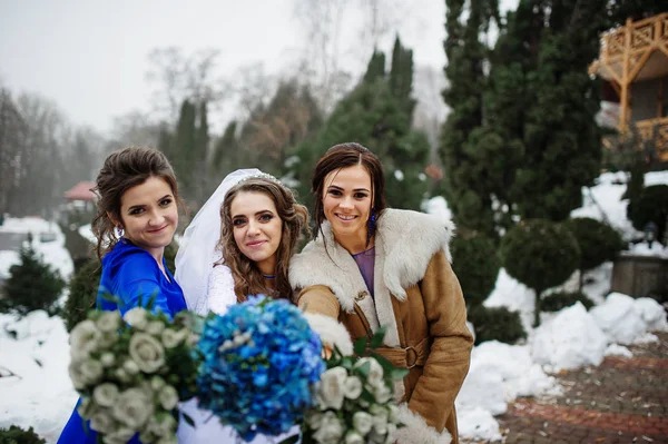 Braut und Brautjungfern mit Blumensträußen auf Händen bei der Winterhochzeit — Stockfoto