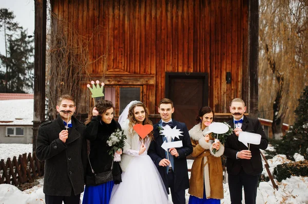 Bruiloft paar met vrienden en nep tabletten op hads achtergrond — Stockfoto