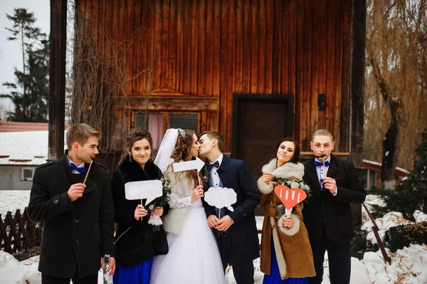 Pareja de boda con amigos y tabletas falsas en el fondo de los hads —  Fotos de Stock