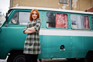 Damalı elbise arka planda yeniden eski genç kırmızı saçlı kız poz