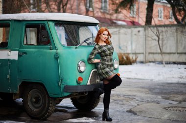 Damalı elbise arka planda yeniden eski genç kırmızı saçlı kız poz