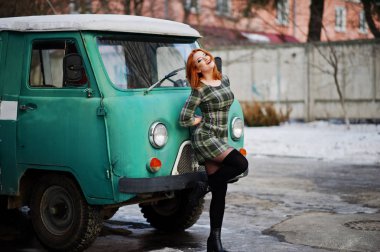 Damalı elbise arka planda yeniden eski genç kırmızı saçlı kız poz