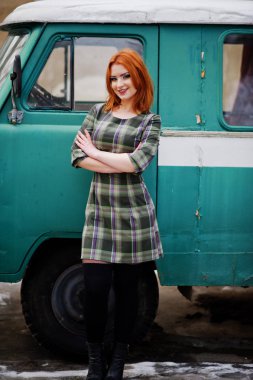 Damalı elbise arka planda yeniden eski genç kırmızı saçlı kız poz