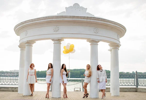 П'ять дівчат з повітряними кулями носили на білих сукнях на курці — стокове фото