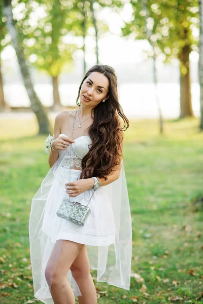 Portret van brunette meisje dragen op witte jurk met tas agai — Stockfoto
