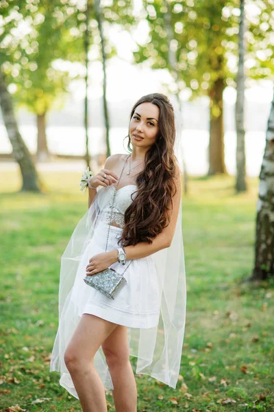 Portret van brunette meisje dragen op witte jurk met tas agai — Stockfoto