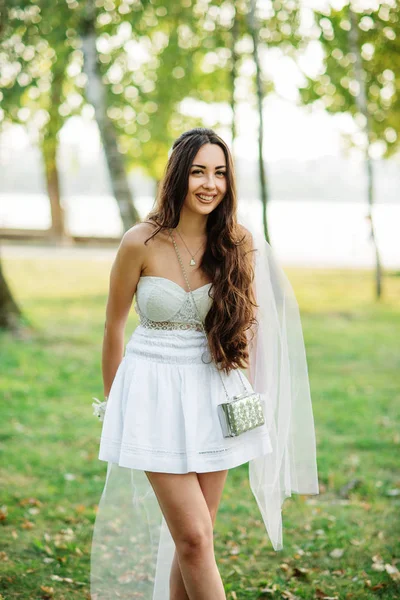 Portret van brunette meisje dragen op witte jurk met tas agai — Stockfoto