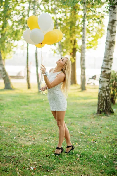 Portret van blond meisje dragen op witte jurk met ballonnen op — Stockfoto