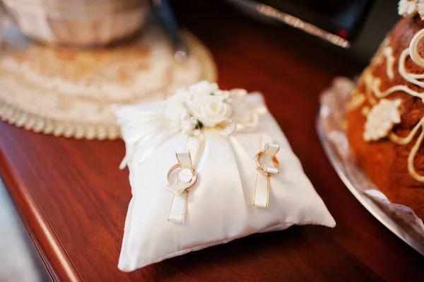 Anillos de boda dorados en almohada pequeña en la ceremonia . — Foto de Stock