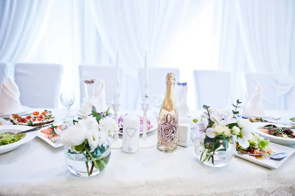 Champán con velas y flores decoración en la mesa de los recién casados a — Foto de Stock