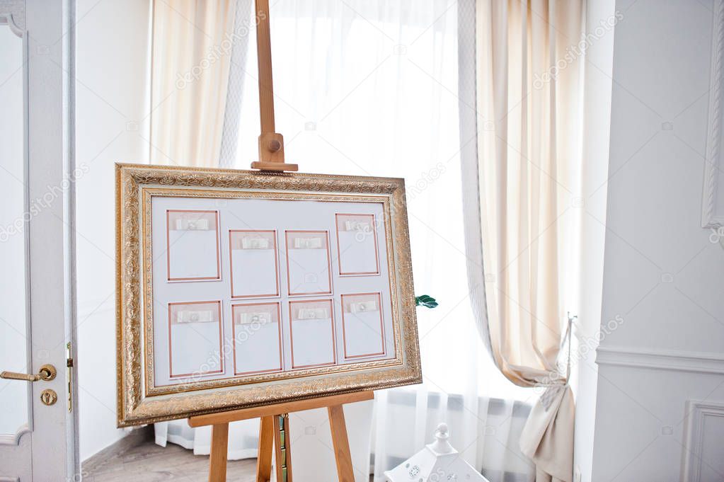 Wedding seating chart on the easel at light restaurant.
