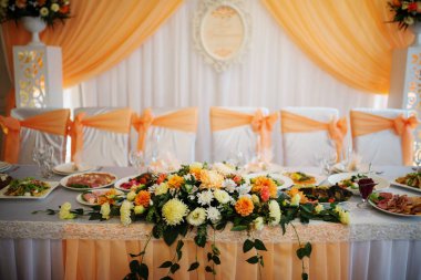 Yeni evliler, masaya çiçek turuncu bileşimi.