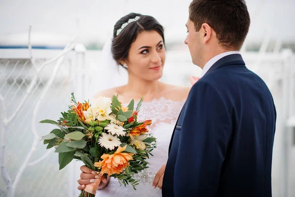 Bröllopsparet bo på piren kaj på mulen dag. — Stockfoto