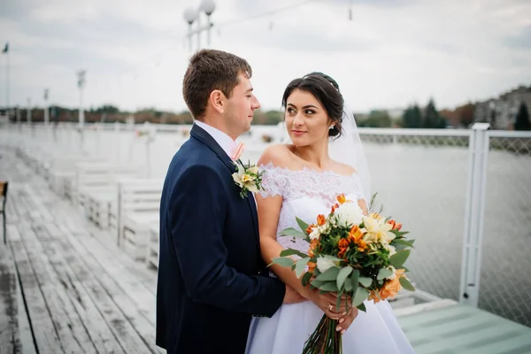 Wedding couple stay on the pier berth at cloudy day. — Stock Photo, Image