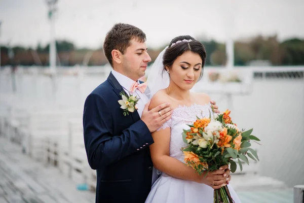 Couple de mariage rester sur la jetée couchette à la journée nuageuse . — Photo