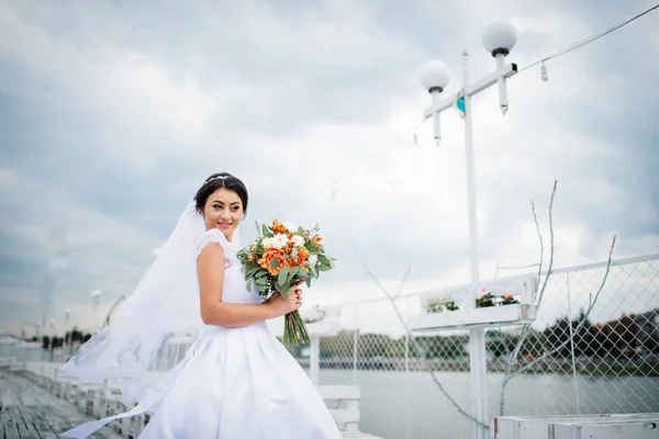 Брюнетка невеста остается на причале в пасмурный день . — стоковое фото