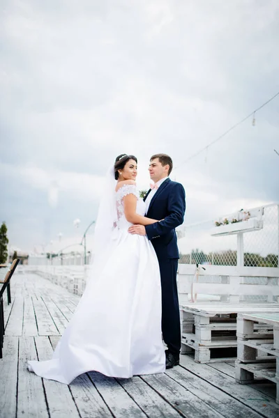 Matrimonio coppia soggiorno sul molo ormeggio al giorno nuvoloso . — Foto Stock