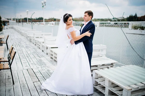 新婚夫妇在码头泊位留在阴天. — 图库照片