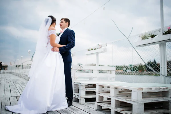 Bruidspaar verblijven op de pier ligplaats bewolkte dag. — Stockfoto