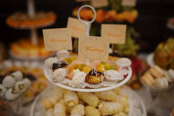 Sweet delicious cakes on plate at wedding reception. — Stock Photo, Image