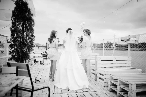 Braut mit Brautjungfern posierte bei bewölkter Hochzeit auf dem Steg — Stockfoto