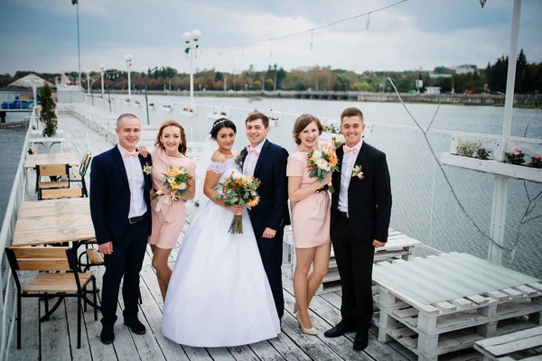 Hochzeitspaar mit Brautjungfern und Trauzeugen übernachtet auf der Seebrücke — Stockfoto