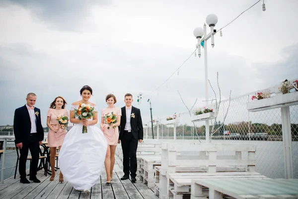 Couple de mariage avec demoiselles d'honneur et les meilleurs hommes restent sur la jetée b — Photo