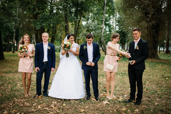Свадебная пара с подружками невесты и шаферы пьют шампанское в — стоковое фото