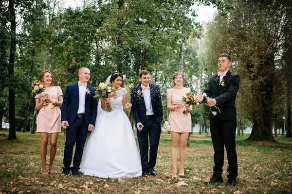 Boda pareja con damas de honor y los mejores hombres beber champán en — Foto de Stock