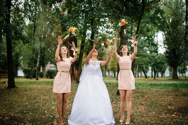 Novia con damas de honor arrojar ramo en el día de la boda . —  Fotos de Stock