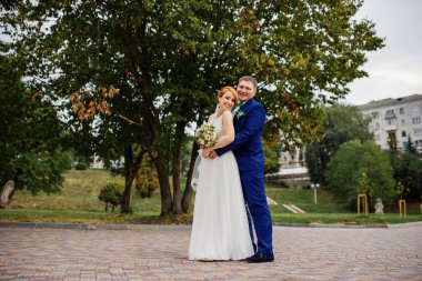 Düğün çifti, bulutlu gün arka plan ağaç aşık.