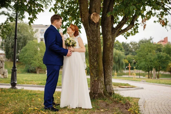 Hochzeitspaar verliebt bei bewölktem Tag Hintergrund Bäume. — Stockfoto