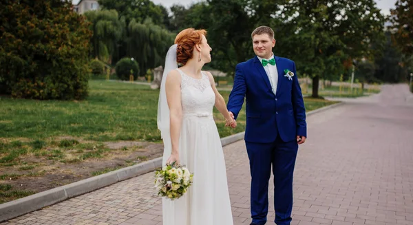 Para ślub zakochany w pochmurny dzień, chodzenie na miasto. — Zdjęcie stockowe