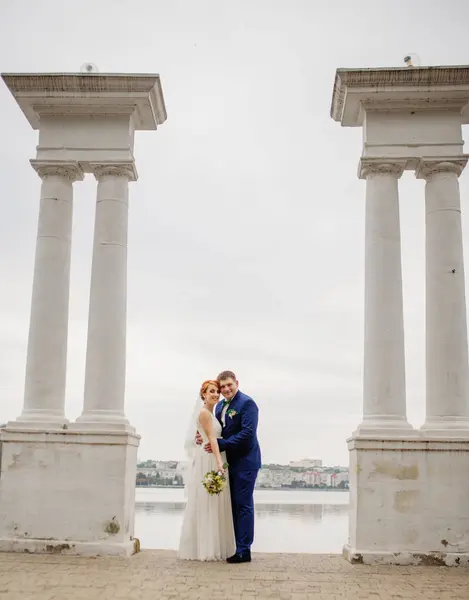 Matrimonio coppia sfondo due colonne sul lago . — Foto Stock