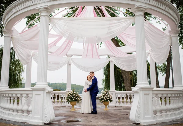 ピンク素材装飾と大規模なアーチの下でカップルを結婚式 wi — ストック写真